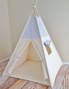 a teepee is sitting on the floor next to a wall