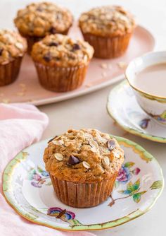 muffins with chocolate chips and coffee on a plate next to another cup of coffee