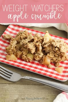 an apple crumble on a red and white checkered plate next to a fork