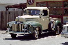 an old truck parked in front of a building