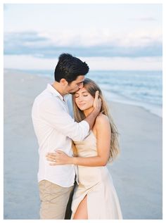 a man and woman embracing on the beach