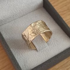 a gold ring sitting in a box on top of a table