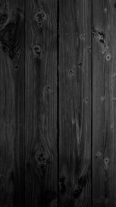 black and white photograph of wood planks with knots in the middle, showing dark staining