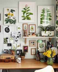 a wooden desk topped with lots of pictures and plants