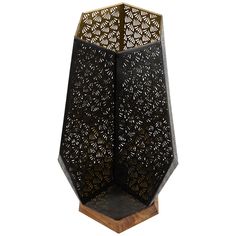 an intricately designed black vase with wooden stand on the bottom and sides, sitting in front of a white background