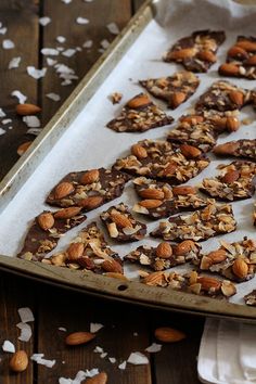 almonds and chocolate are arranged on a baking sheet to make granola bars for dessert