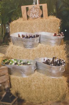 there is a cake made out of hay and buckets filled with drinks on it