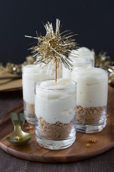 three candles with white frosting and gold sprinkles on a wooden tray