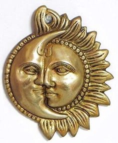 a golden sun and moon face hanging on a wall