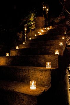 candles are lit on the steps outside at night