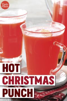 two glasses of hot christmas punch sitting on a table with the words hot christmas punch in front of them