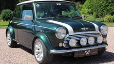 a green and white mini car parked on gravel