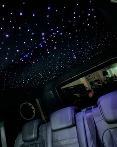 the interior of a car with stars on the ceiling