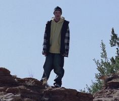 a man standing on top of a rocky cliff