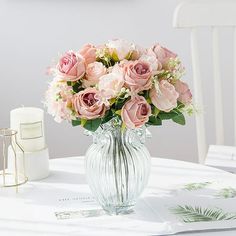 a vase filled with pink flowers sitting on top of a table