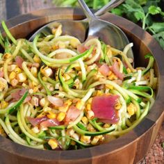 a wooden bowl filled with zucchini and corn