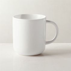 a white coffee cup sitting on top of a table