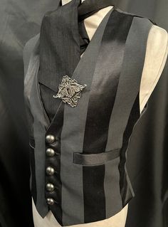 "3 items include :- waistcoat, cravat and hand crafted pin. This is a stunning black heavy suiting fabric waist coat.It is fully lined .It has wide stripes. It has  pockets and adjustable back  . It has gunmetal  buttons. It comes with a black cravat and hand crafted metal pin .  Available in two sizes:- M chest 40\" L chest 44\"  Adjustable waist . High quality well made Makes a stunning steampunk gentleman's outfit! Thank you for looking" Elegant Pinstripe Vest For Formal Occasions, Steampunk Black Vest For Costume Party, Steampunk Formal Sleeveless Vest, Black Steampunk Vest For Costume Party, Formal Steampunk Sleeveless Vest, Gothic Black Vest For Costume, Gothic Black Vest For Costume Party, Black Gothic Costume Vest, Formal Sleeveless Steampunk Vest