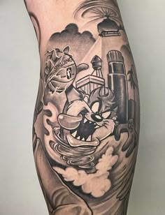 a man's leg with tattoos on it and an image of a ship in the water