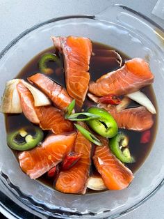 a glass bowl filled with fish and vegetables