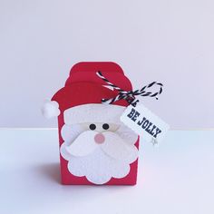 a red box with a santa clause on it and a tag hanging from the top