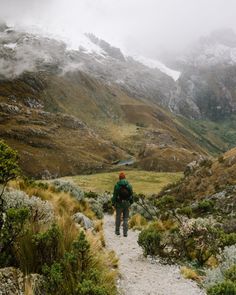 a person walking up a trail in the mountains