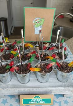 an assortment of desserts in buckets with spoons and forks sitting on a table