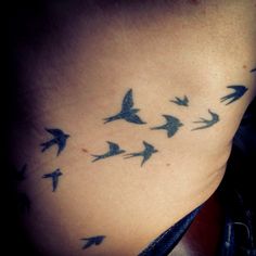 a woman's stomach with birds flying in the air