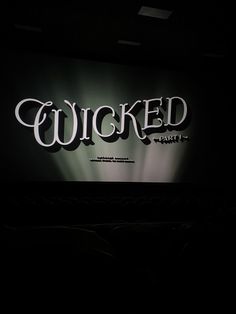 the word'wiicked'is lit up at night in front of an audience