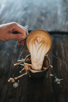 a person is pouring coffee into a cup with the shape of a flower on it