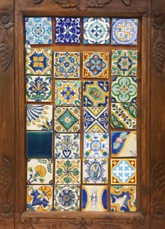 a wooden frame with many different colored tiles on it