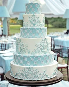 a blue and white wedding cake sitting on top of a table