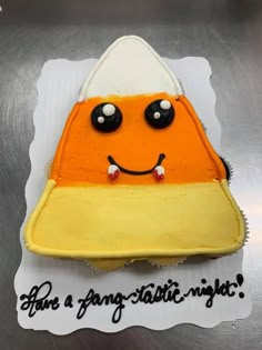 a cake that has been decorated to look like an orange and white hat with black eyes