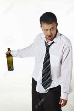 a man in a tie holding a wine bottle and looking at the camera with an angry look on his face