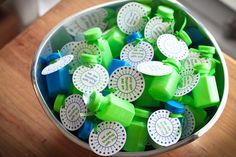 a bucket filled with lots of green and blue candies on top of a wooden table