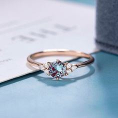 a close up of a ring on top of a blue and white surface with a card in the background