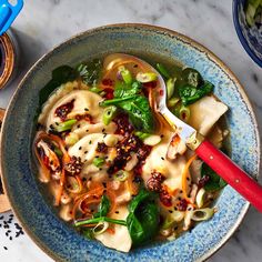 a bowl filled with noodles and vegetables on top of a marble table next to other bowls