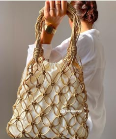 a woman is holding a purse made out of rope