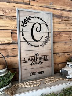 a wooden sign that says the campbell family on top of a shelf next to other decorations