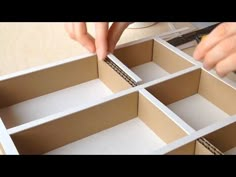 someone is making a box out of cardboard and glues it into the bottom part