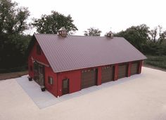 an aerial view of a red barn with two garages