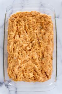 a casserole dish filled with macaroni and cheese on a marble counter top