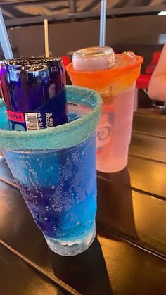 three different colored drinks sitting on top of a table