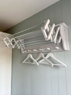 a rack with clothes hanging on it in front of a wall mounted coat hanger