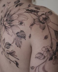 the back of a woman's shoulder with flowers on it