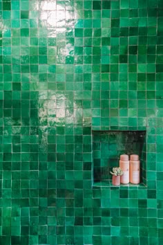 green tiled bathroom with three candles on the window sill