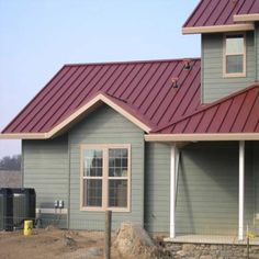 a house with a red metal roof and two windows