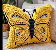 a yellow butterfly pillow sitting on top of a white couch