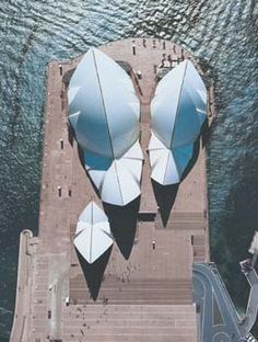 an aerial view of some boats in the water near a dock with stairs and railings