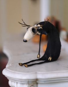 a figurine of a horse wearing a black hat with gold horns on it's head